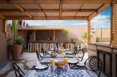 a patio with a table and chairs on a patio at Riad Bibazia in Marrakech