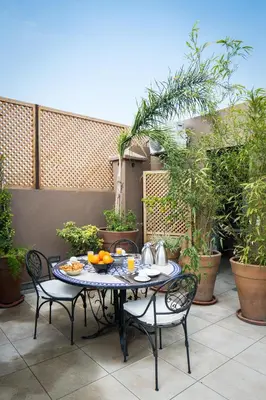 a table with chairs and fruit on a patio at Riad Bibazia in Marrakech