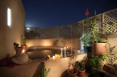 a room with a bath tub with plants and candles at Dar Lalla F'dila in Marrakech