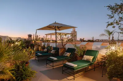 a group of chairs and an umbrella on a patio at Dar Lalla F'dila in Marrakech