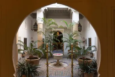 an arched hallway with palm trees in a building at Dar Lalla F'dila in Marrakech