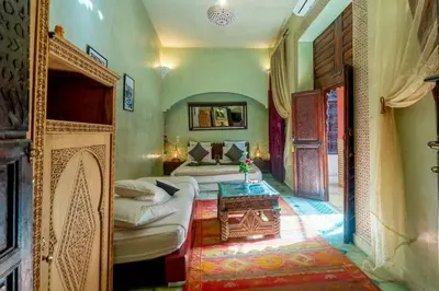 a bedroom with two beds and a table in it at Riad Rêves D'orient & Spa in Marrakech