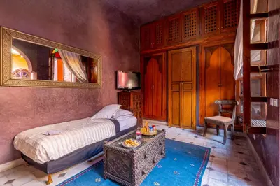 a bedroom with a bed and a mirror and a table at Riad Rêves D'orient & Spa in Marrakech