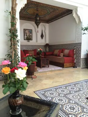 a living room with a couch and a table with flowers at Riad Viva in Marrakech