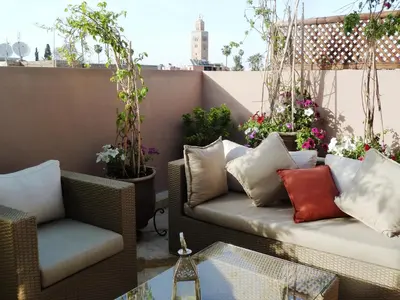 a patio with a couch and chairs on a balcony at Riad Viva in Marrakech