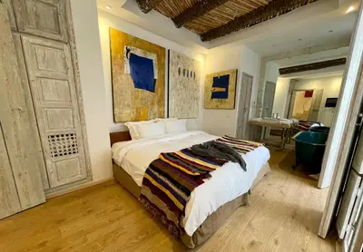 a bedroom with a large bed and a bathroom at BCK Art Riad in Marrakech