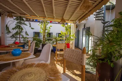 a patio with tables and chairs and potted plants at Riad Les Jardins des Lilas in Marrakech