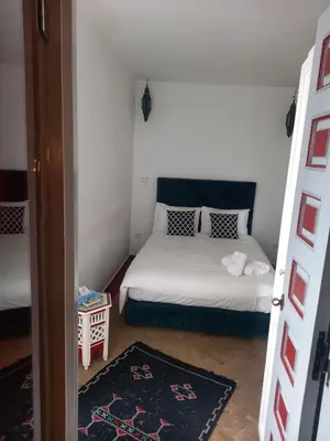 a small room with a bed and a room with a door at Riad Les Jardins des Lilas in Marrakech