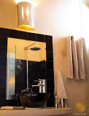 a bathroom with a sink and a mirror at Riad Les Jardins des Lilas in Marrakech