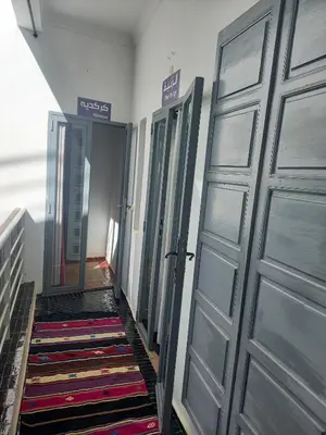 a hallway with a row of doors and a rug at Riad Les Jardins des Lilas in Marrakech