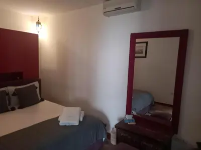 a hotel room with a mirror and a bed at Riad Les Jardins des Lilas in Marrakech