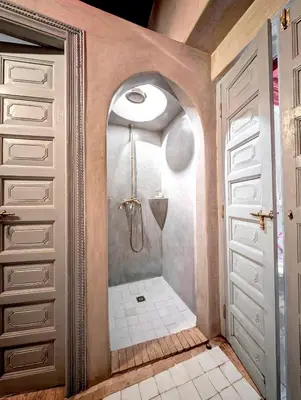 a walk in shower in a bathroom next to a door at Riad Slitine & Spa in Marrakech