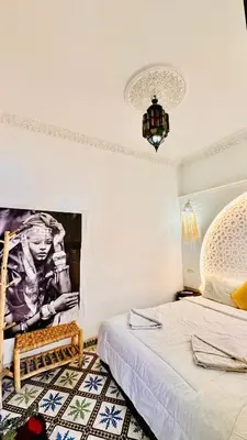a bedroom with a bed and a picture on the wall at Riad 46 in Marrakech