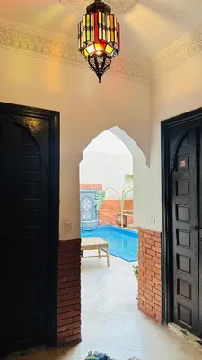 a hallway with two doors and a chandelier at Riad 46 in Marrakech
