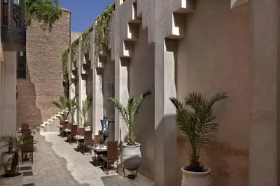 a courtyard with tables and chairs and palm trees at Villa Makassar in Marrakech