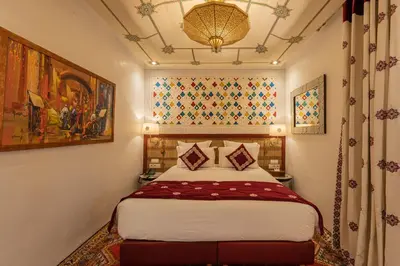 a bedroom with a bed and a painting on the wall at La Maison Arabe Hotel, Spa & Cooking Workshops in Marrakech