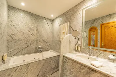 a bathroom with a tub and a sink and a mirror at La Maison Arabe Hotel, Spa & Cooking Workshops in Marrakech