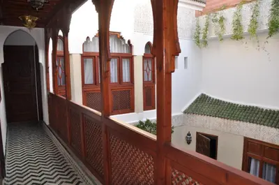 an empty corridor of a building with wooden doors at Riad Belle Epoque in Marrakech