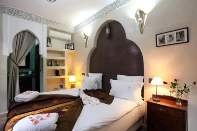 a bedroom with a large bed with a large headboard at Riad Belle Epoque in Marrakech