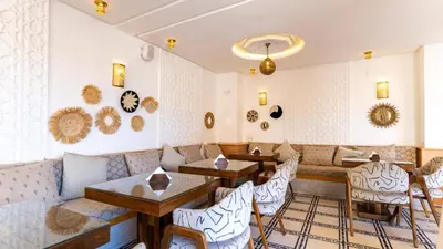 a restaurant with a couch and tables and chairs at Riad Hamdane Rooftop & SPA in Marrakech