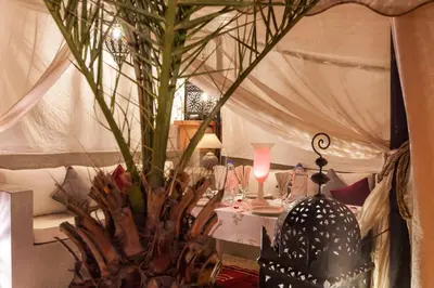 a table with a vase with a plant in it at Riad Shemsi in Marrakech