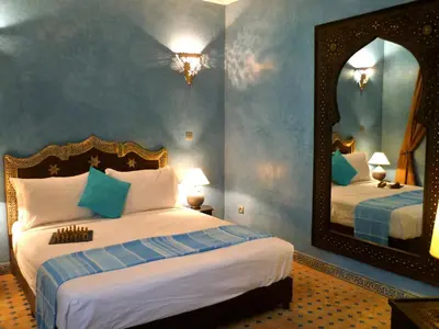a bedroom with a bed and a large mirror at Riad Shemsi in Marrakech