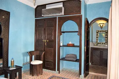 a room with a wooden door and a mirror at Riad Shemsi in Marrakech