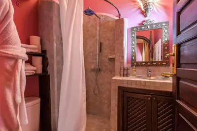 a bathroom with a shower and a sink and a mirror at Riad Shemsi in Marrakech