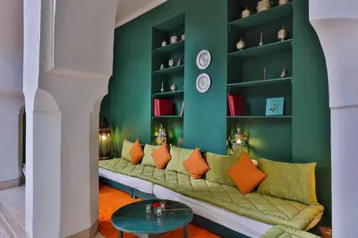 a room with a long couch with orange pillows at Hotel & Spa Dar Sara in Marrakech