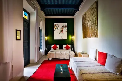 a living room with a bed and a red rug at Hotel & Spa Dar Sara in Marrakech