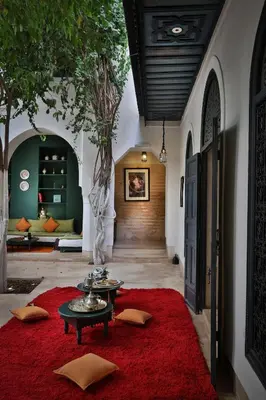 a living room with two tables and a red rug at Hotel & Spa Dar Sara in Marrakech