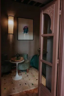 a room with a table and two chairs and a table and a door at Riad 117 in Marrakech