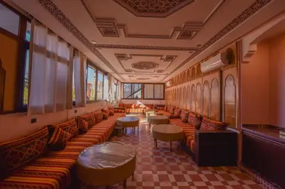 a waiting room with couches and tables and windows at Riad Assia in Marrakech