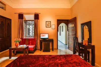 a bedroom with a bed and a couch and a table at Riad & Spa Bahia Salam in Marrakech