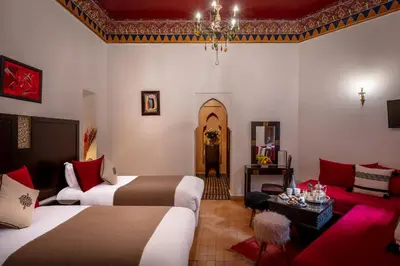 a hotel room with two beds and a couch at Riad & Spa Bahia Salam in Marrakech