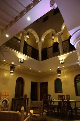 a room with tables and chairs in a building at Riad L'Emir in Marrakech