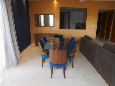 a dining room with a glass table and blue chairs at Jnane Gueliz in Marrakech