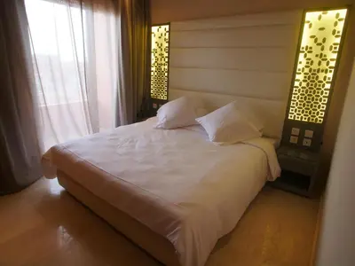 a bedroom with a white bed and a window at Jnane Gueliz in Marrakech
