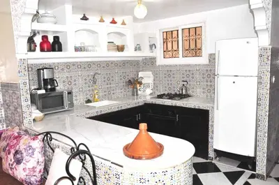 a kitchen with a white refrigerator and a sink at Ryad Nayla in Marrakech