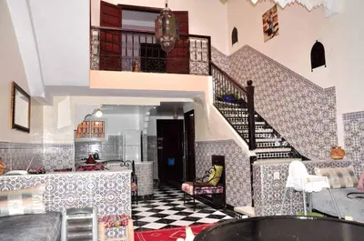 a living room with a staircase in a house at Ryad Nayla in Marrakech