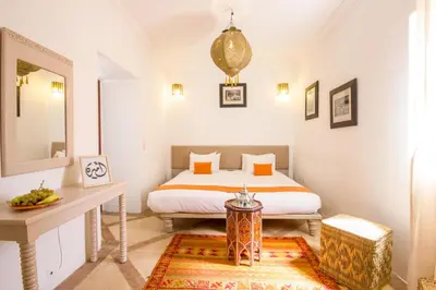 a bedroom with a bed and a table and a mirror at Riad Amira in Marrakech