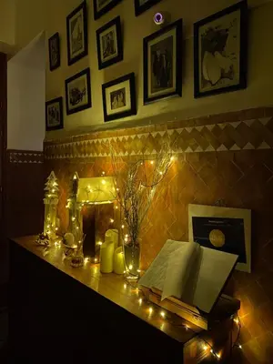 a table with a book and candles and lights at Riad Chameau FDC Hôtel SPA in Marrakech