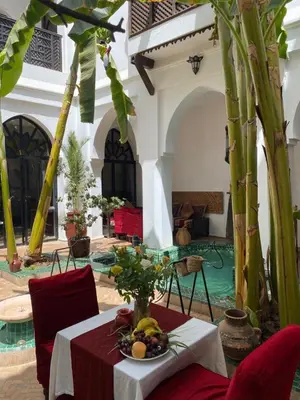 a table with a bowl of fruit on it in a courtyard at Dar Soukaina in Marrakech