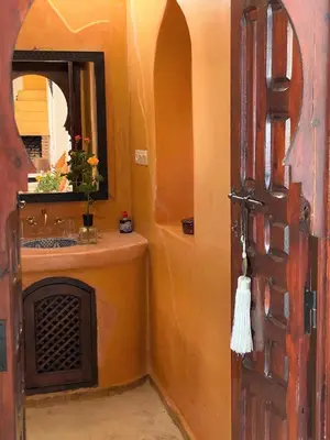 a bathroom with a sink and a mirror and a door at Dar Soukaina in Marrakech