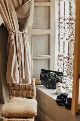 a bathroom with a chair next to a window at Riad Dar Ten in Marrakech