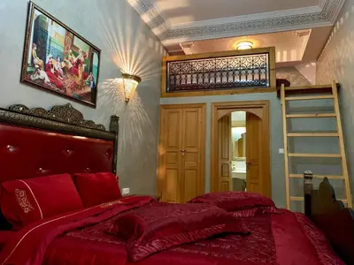 a bedroom with a red bed and a ladder at Riad Miral in Marrakech