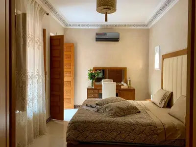 a bedroom with a bed and a desk and a window at Riad Miral in Marrakech