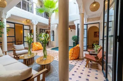 a lobby with couches and tables and a pool at Riad Beldi in Marrakech
