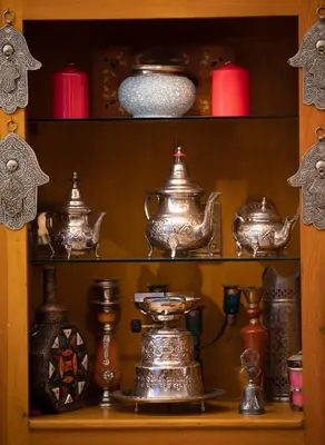 a shelf filled with different types of tea pots and vases at Riad Mboja Chez Ali Baba in Marrakech