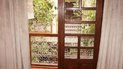 a wooden door with a screened in window at Riad Samsli in Marrakech